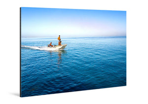 Glossy acrylic photo print of people in a small boat on calm blue ocean water