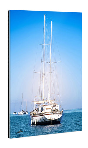 Acrylic photo print of a sailboat on calm blue water under clear sky, with glossy finish.