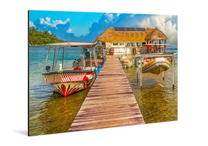 Aluminum photo print of a tropical dock with boats and thatched-roof hut over clear water