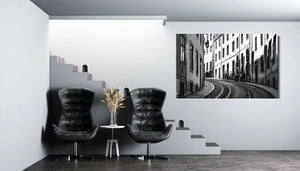 Modern minimal living room with black chairs, white decor, and large black-and-white cityscape wall art
