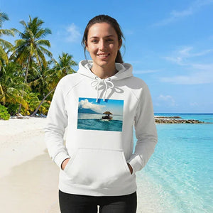 Woman on tropical beach wearing white hoodie with scenic boat and ocean print