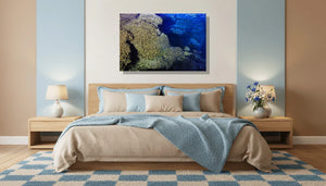 Coral reef wall art above bed in modern bedroom with blue decor and bedside lamps