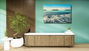 Modern living room with green walls, large ocean photograph, and indoor plants