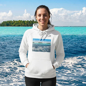 Woman wearing white hoodie with beach photo print, standing by turquoise tropical sea
