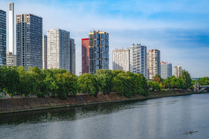Photographie de Paris moderne au bord de la Seine avec immeubles, arbres et ciel bleu
