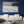 Tableau mural noir et blanc représentant une plage tropicale paisible, bordée de palmiers, avec une silhouette solitaire face à la mer