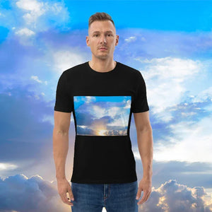 Man wearing black t-shirt with printed sky and clouds artwork, standing against a sky background