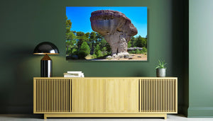 Modern living room with large wall art of unique rock formation and green trees