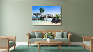 Living room with wooden furniture and wall art of a tropical bridge over clear water