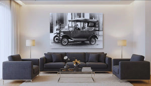 Modern living room with dark sofas, large black and white vintage car photo wall art, and stylish decor