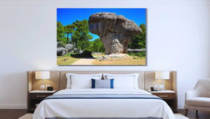 Bedroom interior with large landscape wall art of mushroom-shaped rock and pine trees