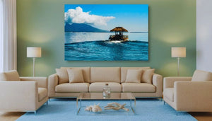Modern living room with beige sofas, glass coffee table, and a large wall art of a boat on blue water