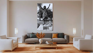Modern living room with large black and white statue photo wall art above a gray sofa