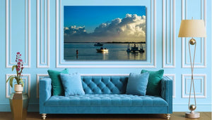 Blue sofa in elegant living room with ocean photography wall art, floor lamp, and plant
