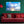 Modern living room with red sofa, green wall, and sunset sky photo art above couch