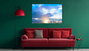 Modern living room with red sofa, green wall, and sunset sky photo art above couch