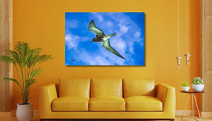 Modern living room with yellow sofa and wall art of a bird flying in blue sky