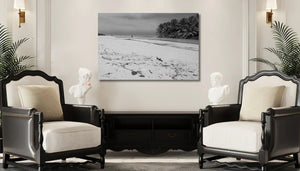 Elegant living room with armchairs, bust sculptures, and black-and-white beach photograph wall art