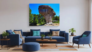 Modern living room with blue couch and large wall art featuring a rock formation landscape