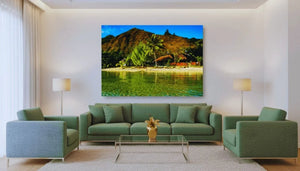 Modern living room with green sofas, large tropical landscape wall art, and glass coffee table