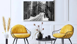 Modern living room with two yellow chairs, black wire frames, and a black-and-white cityscape photo on the wall